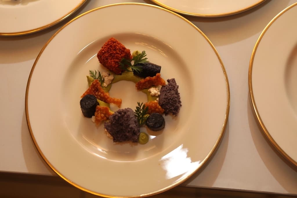 A beautifully plated dish on a gold-rimmed plate